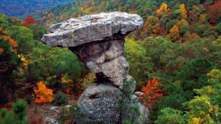 rock formation with trees in the background. Trees are in autumn colors.