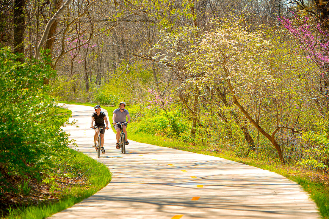Two bikers on a paved trail