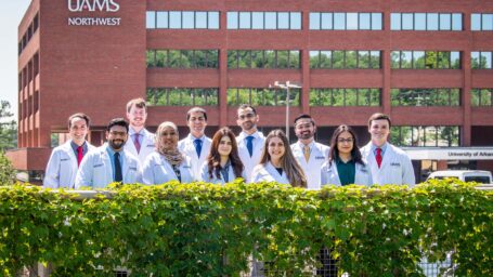 Internal Medicine residents from the UAMS Northwest Campus pose on the pedestrian bridge in front of the campus building in Fayetteville.
